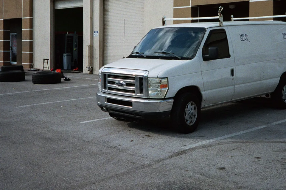 Pickup and commercial van parked in an industrial setting